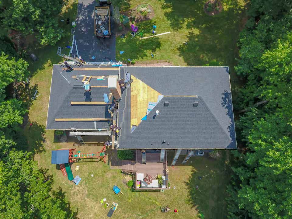 aerial view of home having roof repaired; best roofing materials 
