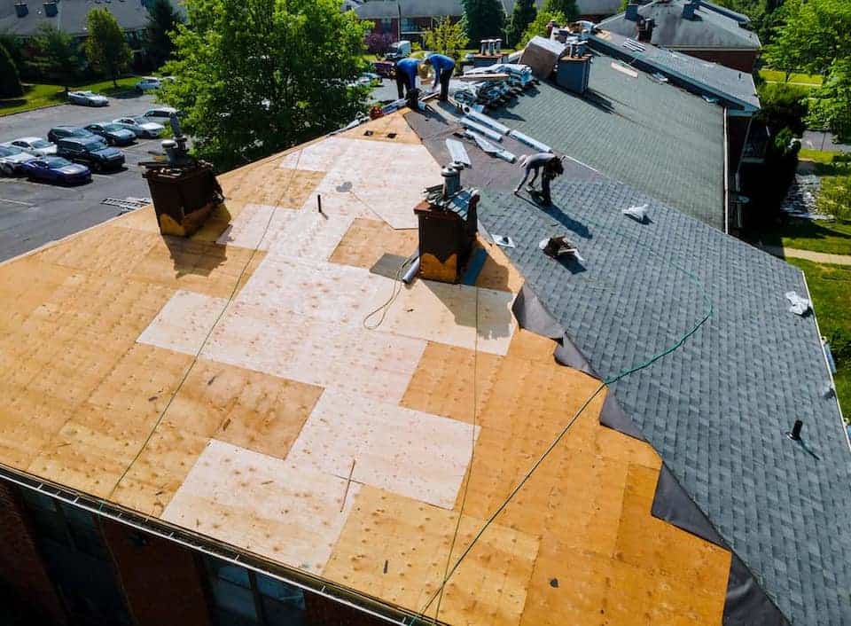aerial view of contractors repairing home roof; roofing materials